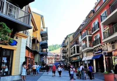 a group of people walking down a street with buildings at Slopeside Sanctuary - Ski In/Ski Out in Blue Mountains