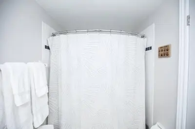 a bathroom with a shower with a white shower curtain at Slopeside Sanctuary - Ski In/Ski Out in Blue Mountains