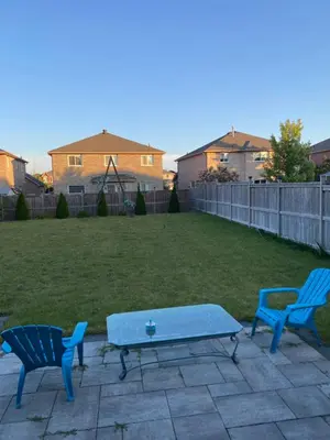 two blue chairs and a table in a yard at Cozy 3 bedroom home perfect for small gatherings in Barrie