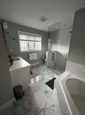 a bathroom with a tub and a sink and a mirror at Cozy 3 bedroom home perfect for small gatherings in Barrie