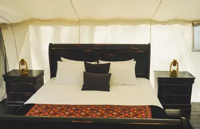 a bedroom with a black and white bed with two night stands at Fronterra Wellness Farm & Camp in Hillier