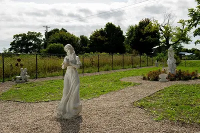 a statue of a woman standing in a garden at Villa di Casa - Boutique Hotel in Wellington
