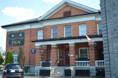 a brick building with a sign in front of it at The King George Inn in Cobourg