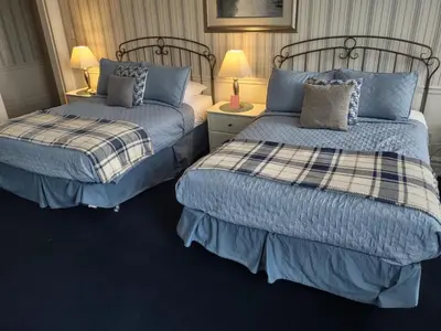 two beds sitting next to each other in a room at The King George Inn in Cobourg