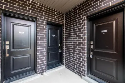 two black doors on a brick wall at Exquisite 2 Bedroom Apt, mins to the falls. in Niagara Falls