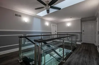 a room with a glass staircase with a ceiling fan at Niagara Luxury Suites in Niagara Falls
