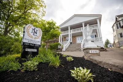 a house with a sign in front of it at Niagara Luxury Suites in Niagara Falls