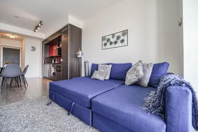 a blue couch in a living room with a table at RHD Luxury Condos-Downtown, CN Tower, Metro Toronto Convention Centre, Rogers Centre, Free Parking in Toronto