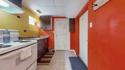 a kitchen with orange and yellow walls and a door at ZARA's UNIQUE APARTMENT in Mississauga