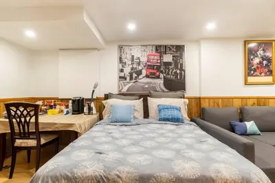 a bedroom with a bed and a table and a red bus at BIG Oasis Studio near Airport YYZ in Toronto