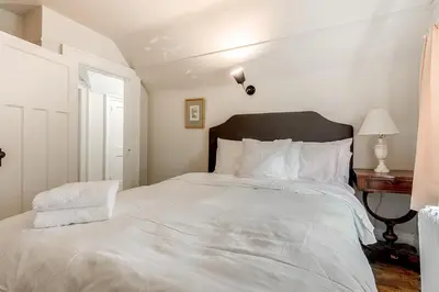 a bedroom with a large bed with white sheets at Four Bedroom Rosedale Home in Toronto