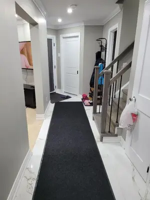 a hallway with a black carpet and a stair case at Classic & Luxury Private Detached Entire Home with Free WI-FI & T.V in Brampton