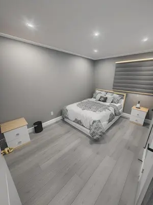 a bedroom with a large bed and wooden floors at Classic & Luxury Private Detached Entire Home with Free WI-FI & T.V in Brampton