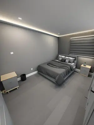 a bedroom with a bed and two tables in it at Classic & Luxury Private Detached Entire Home with Free WI-FI & T.V in Brampton