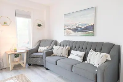 a living room with a gray couch and a chair at Family-Friendly Boho Stay - Sleeps 10 - Near the Falls in Thorold