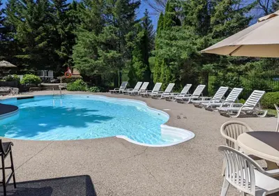 a swimming pool with chairs and an umbrella at Steps to Blue Mtn Condo wt Elegant Style 213 Sierra Lane in Blue Mountains