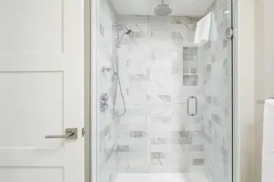 a white bathroom with a shower with a glass door at Steps to Blue Mtn Condo wt Elegant Style 213 Sierra Lane in Blue Mountains