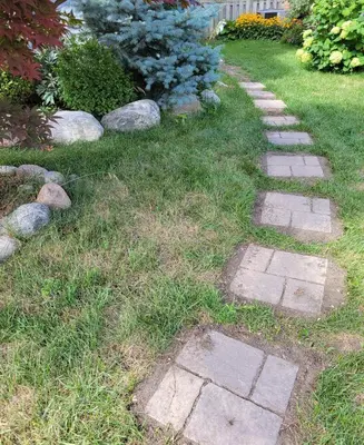 a stone path in a yard with grass and rocks at Guest Suite in Whitby in Whitby