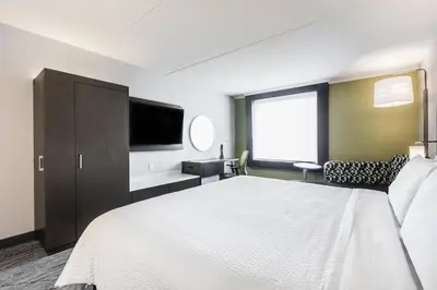 a bedroom with a large bed and a flat screen tv at Holiday Inn Express & Suites Toronto Airport South by IHG in Toronto