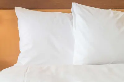 a stack of white pillows on a bed at Holiday Inn Express & Suites Toronto Airport South by IHG in Toronto