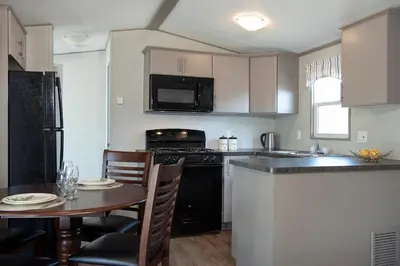 a kitchen with a table and a kitchen with a stove top oven at Vine Ridge Resort - Cottages in Niagara on the Lake