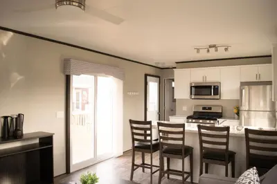 a kitchen with chairs and a kitchen island with a stove at Vine Ridge Resort - Cottages in Niagara on the Lake