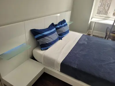 a bed with two blue pillows on top of it at Modern House in Toronto in Toronto
