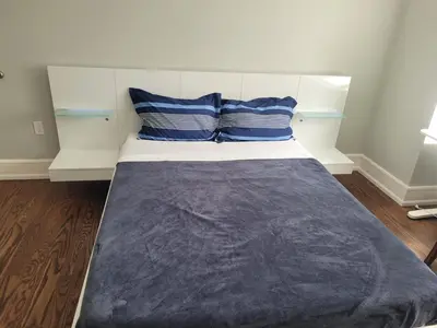a bed with blue and white pillows in a room at Modern House in Toronto in Toronto