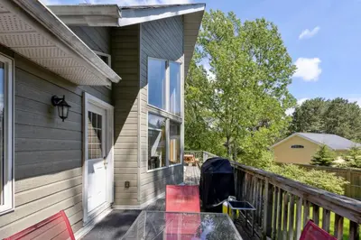 a balcony with red chairs and a table on a house at 10 Bedroom Executive Chalet w Hot Tub in Blue Mountains