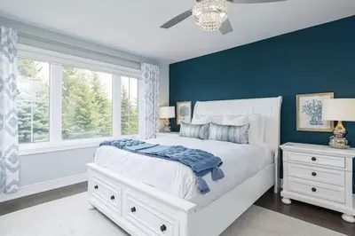 a bedroom with a white bed and a blue wall at Exceptional 3 BDRM Townhome - 4 Seasons Rental in Collingwood