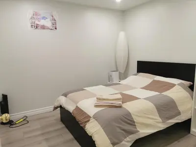 a bedroom with a bed with a checkered blanket at Perfect location comfort private house lower level 2 bedroom unit in Mississauga