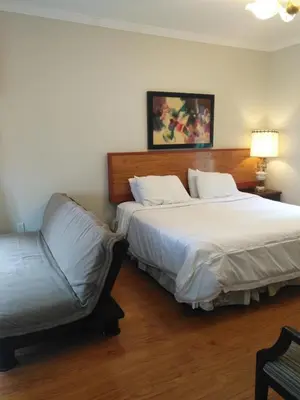 a hotel room with two beds and a chair at Lakeview private suite-Twin or king in Tottenham
