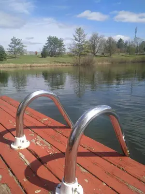a boat with a metal railing on a body of water at Lakeview private suite-Twin or king in Tottenham