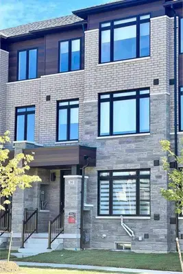 a large brick building with windows on a street at NEWLY BUILT LUXURIOUS 3BRM TOWN HS/AIRPORT/PARKING in Brampton