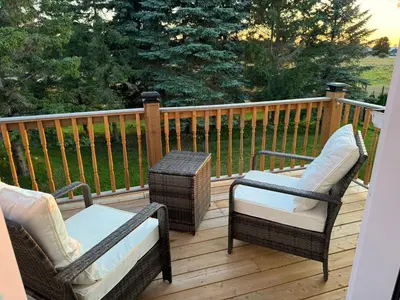 two chairs and a table on a deck at Farmhouse Resort in Midhurst