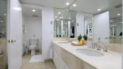a bathroom with two sinks and a toilet and mirrors at Carriage Hills Retreat Rental in Edgar