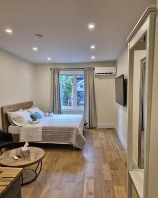 a hotel room with a bed and a window at Gabby's Place Downtown Core in Toronto
