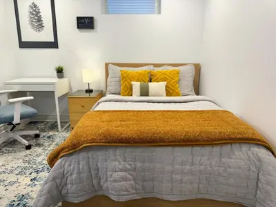 a bedroom with a bed with yellow pillows and a desk at The Khan Villa in Whitby