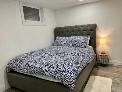 a bedroom with a bed with a black and white comforter at Adorable 1 Bedroom Suite With Kitchen Fireplace in Cambridge