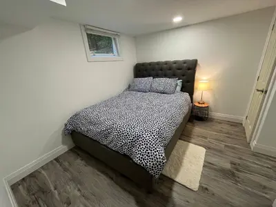 a bedroom with a bed with a black headboard at Adorable 1 Bedroom Suite With Kitchen Fireplace in Cambridge