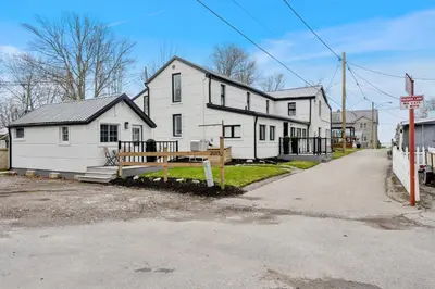 a large white house with a gate in front of it at Luxe Lodges on Lake Erie in Port Dover