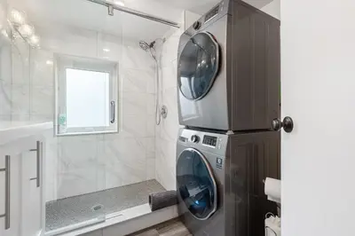 a bathroom with a washing machine and a shower at Luxe Lodges on Lake Erie in Port Dover