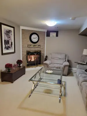 a living room with a couch and a fireplace at Cozy Suite with HOT TUB & Highspeed Internet in Grimsby