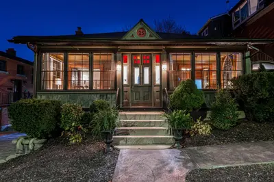 a green house with a front door and windows at Lake Suite with Sunroom by Henry House Stays in Stratford