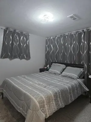 a bedroom with a large bed with a gray headboard at Falstaff Home in Toronto