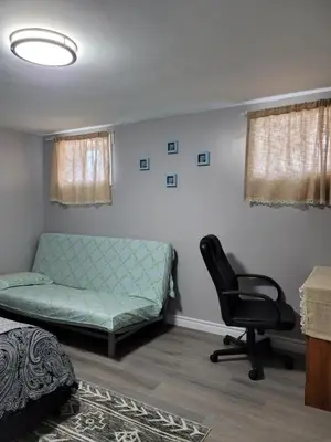 a bedroom with a bed and a chair and a couch at Falstaff Home in Toronto