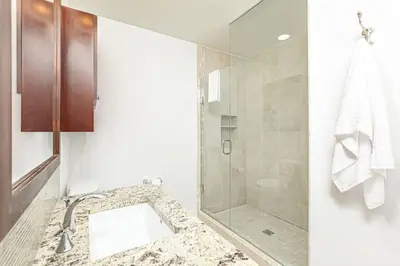 a bathroom with a glass shower and a sink at Luxurious Rivergrass Blue Mountain Retreat in Blue Mountains