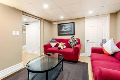 a red couch with a dog laying on it in a living room at The Rustic Barn in Brampton