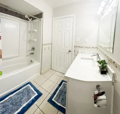 a white bathroom with a tub and a sink at Full Privacy Apartment with Free Parkrings in Toronto