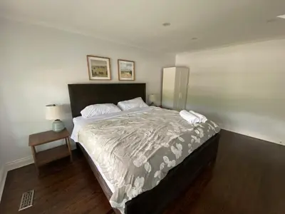 a bedroom with a large bed and a table at Yonge and Finch Subway !L Spacious & Bright Private Bedroom with Shared Amenties in Toronto